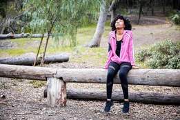 woman sitting on log in woods